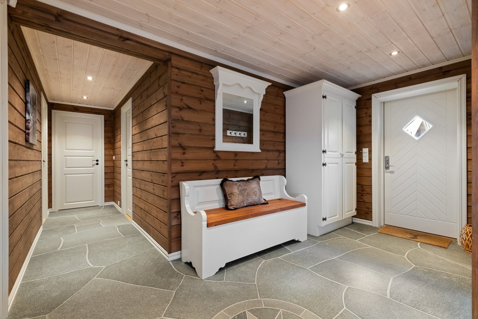 Entré med skifer på gulv med varmekabler som gir en lun velkomst inn i hytta Galleribilde