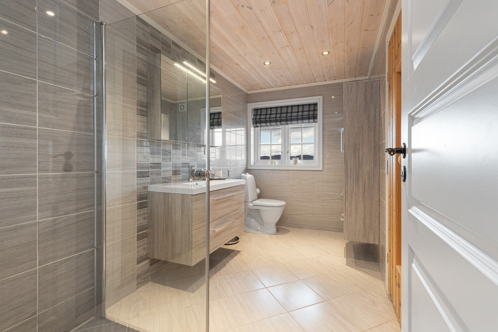 Badet som ligger i første etasje har delikate fliser på vegger og gulv som gir et lekkert uttrykk Galleribilde