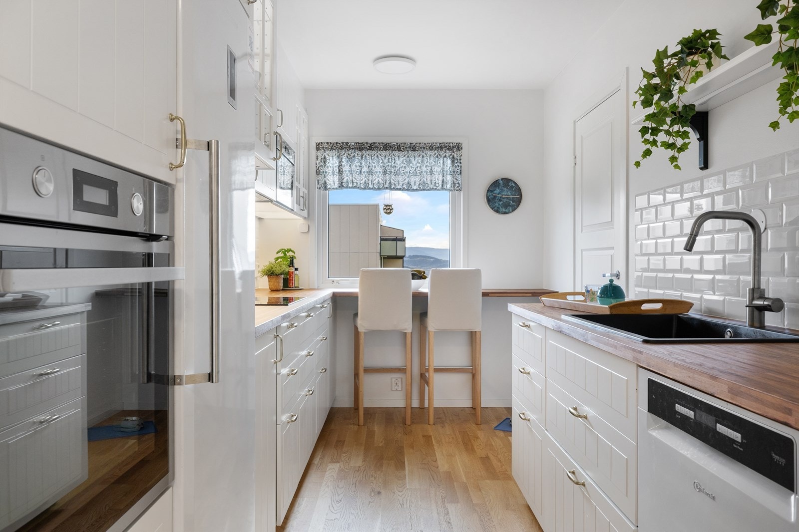 Kjøkkenet ble fornyet i 2022 og består av en takhøy IKEA-innredning med profilerte, hvite fronter Galleribilde