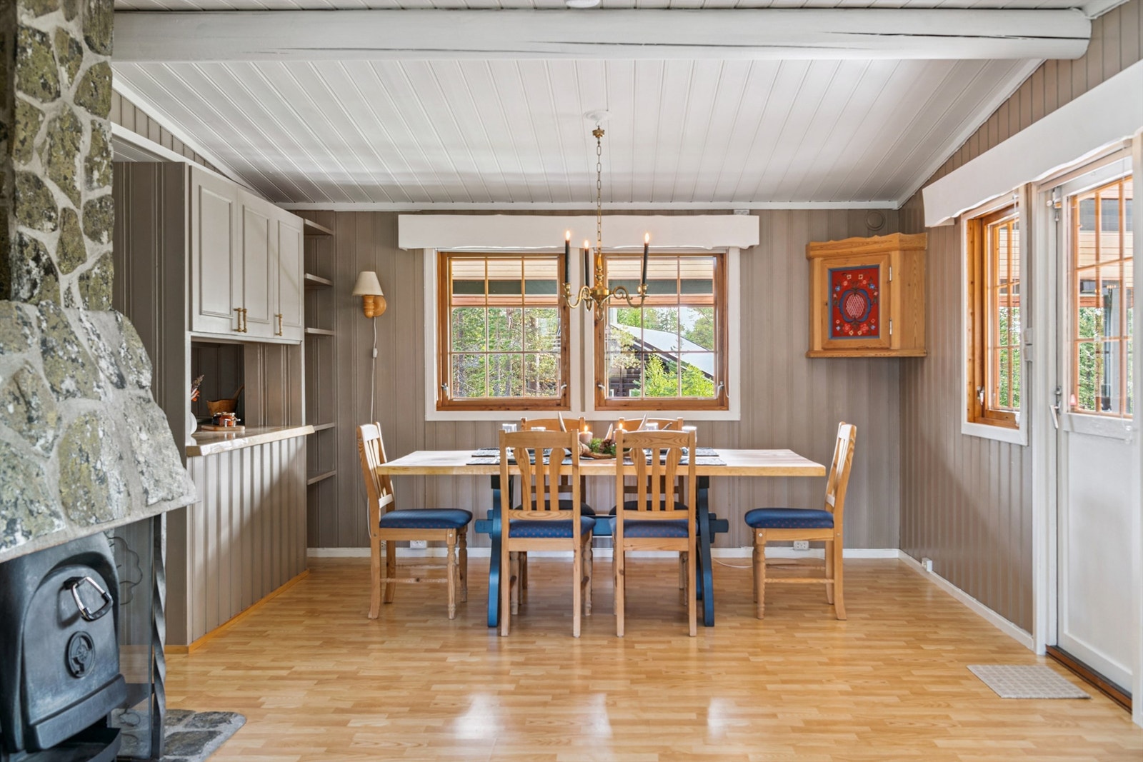 Spisestuen har plass til et stort spisebord og har en sjarmerende, natursteinforblendet pipe. Galleribilde