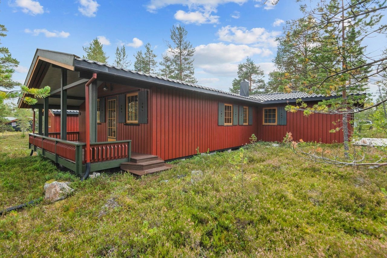 Fritidsboligen har en klassisk stil med stående panel og tak tekket med stålplater. Galleribilde