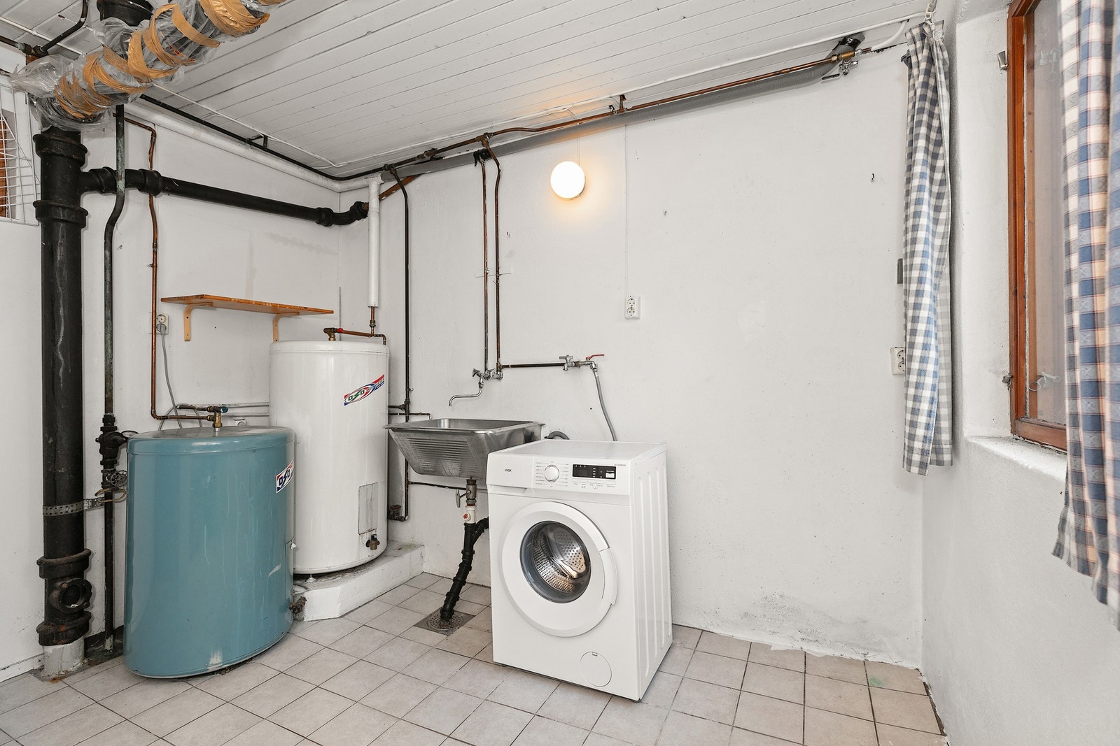 I underetasjen ligger et eget vaskerom med utslagsvask, opplegg for vaskemaskin og varmtvannsberedere. Galleribilde