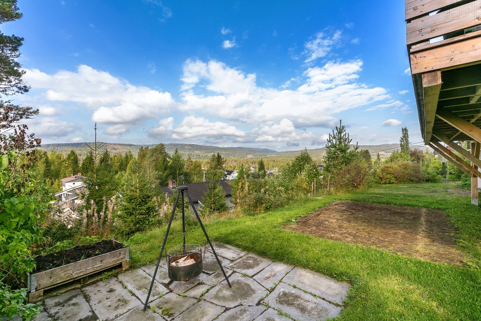 Tomten er pent opparbeidet med steinheller, grønne plenarealer og variert beplantning som gir et trivelig inntrykk. Galleribilde