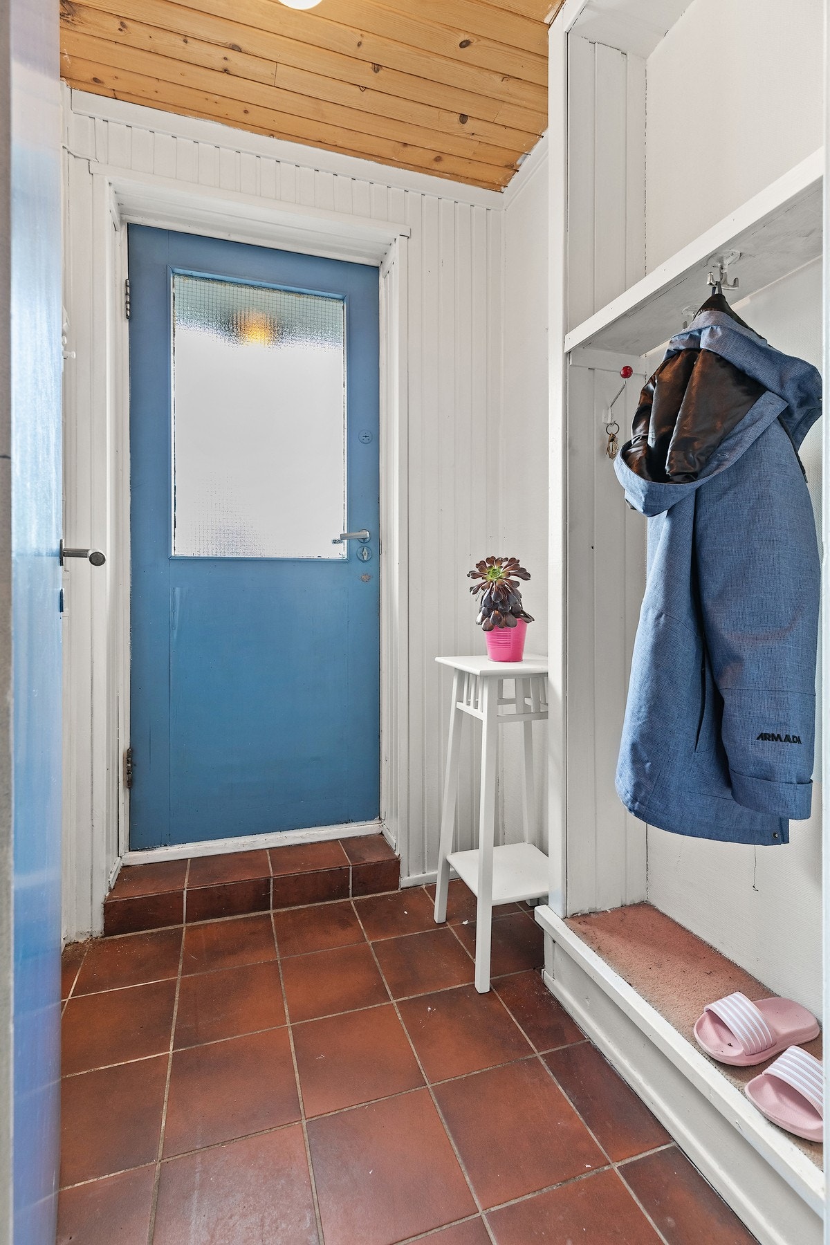 I underetasjen er inngangspartiet flislagt og praktisk løst med plassbygde hyller. Galleribilde