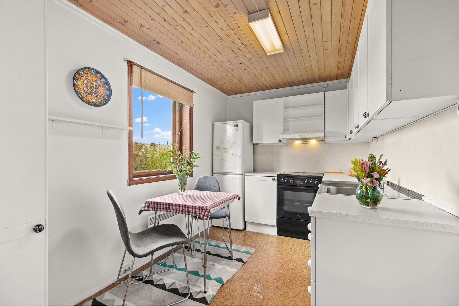 Kjøkkenet er fra byggeåret og har enkel, men funksjonell innredning med glatte fronter. Benkeplaten er i laminat og rustfritt stål, med nedfelt oppvaskkum og ett-greps armatur. Galleribilde