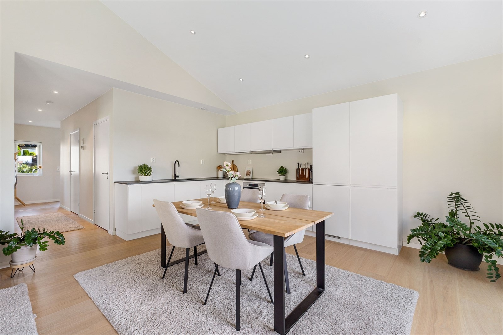 Kjøkkenet har hvite, slette fronter, sort laminat benkeplate og integrerte hvitevarer - alt du trenger for en funksjonell og moderne hverdag. Galleribilde