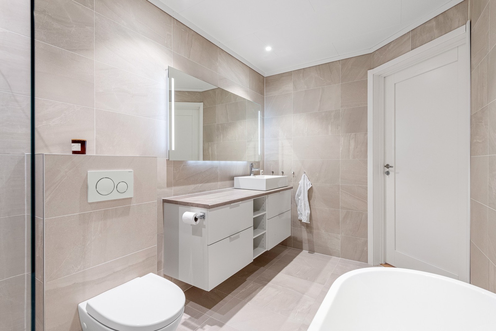 Stor baderomsinnredning og vegghengt speil med lys. Galleribilde