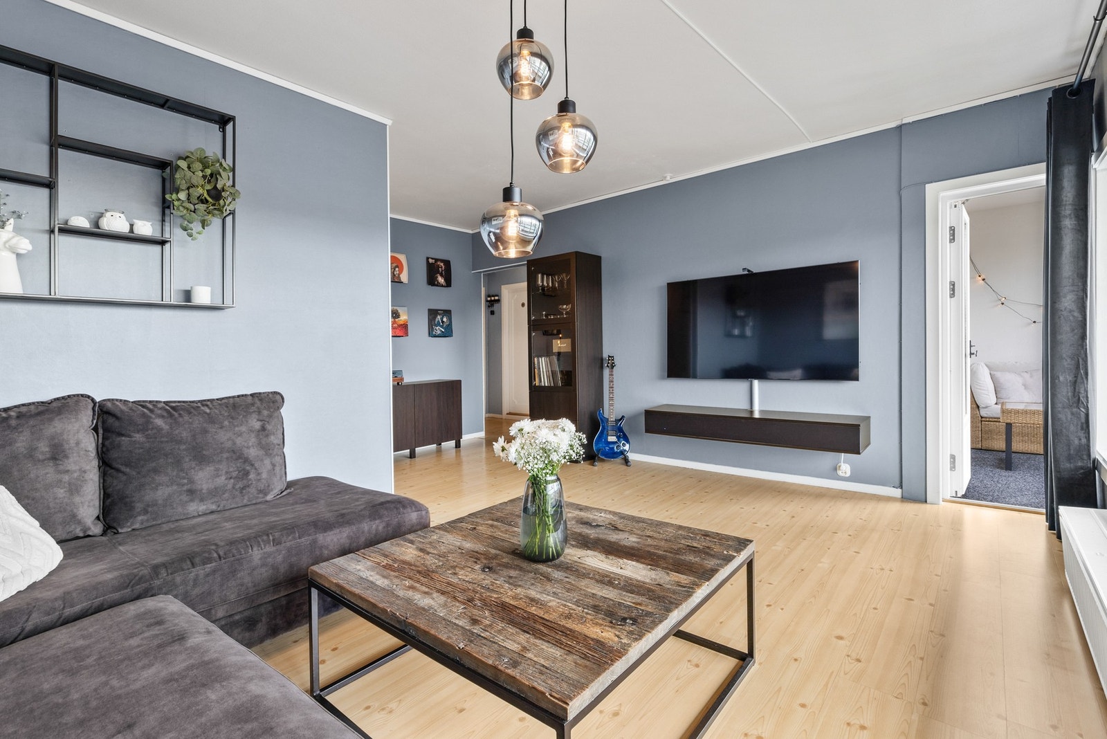 Pen stue med laminatgulv og naturlig lys fra store vindusflater. Galleribilde