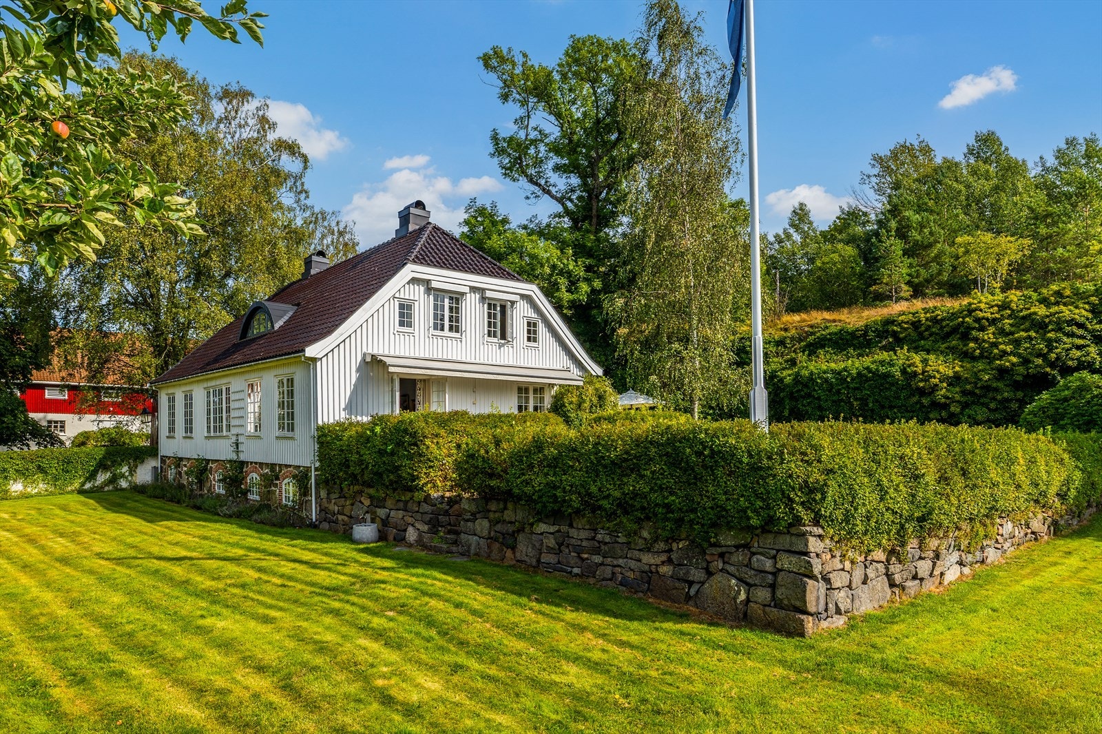 Deler av hagen hviler på tørrstablet natursteinsmur, med trapp ned til en nydelig frukthage med ekstra boltreplass. Galleribilde