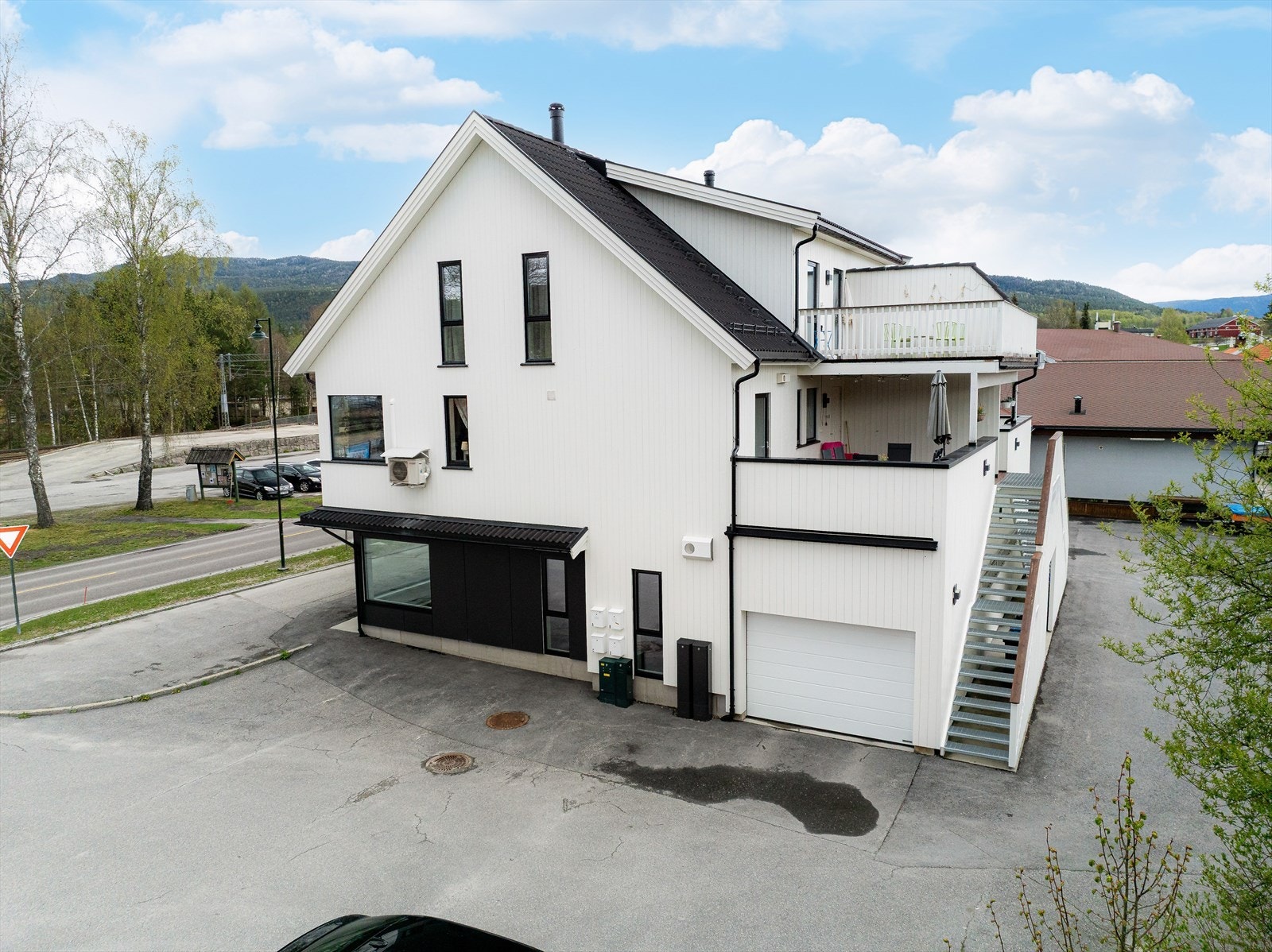 Tomten er pent opparbeidet med stor, asfaltert gårdsplass med gode parkeringsmuligheter, samt flere parkeringsplasser i garasjer. Galleribilde