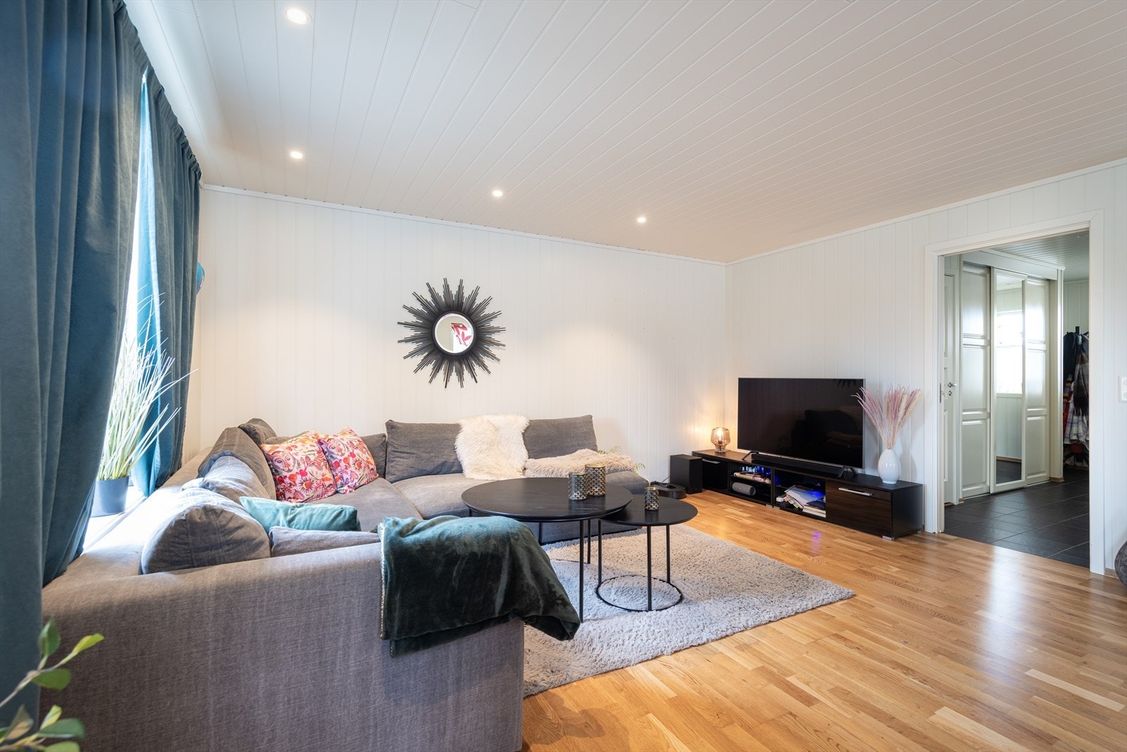 Stuene har parkett på gulv, smartpanel på vegger og i tak, samt spotter flere steder. Galleribilde