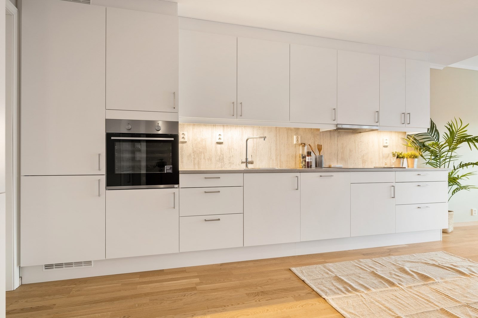 Kjøkkeninnredningen har rikelig med plass i både skaper og skuffer og integrerte hvitevarer Galleribilde