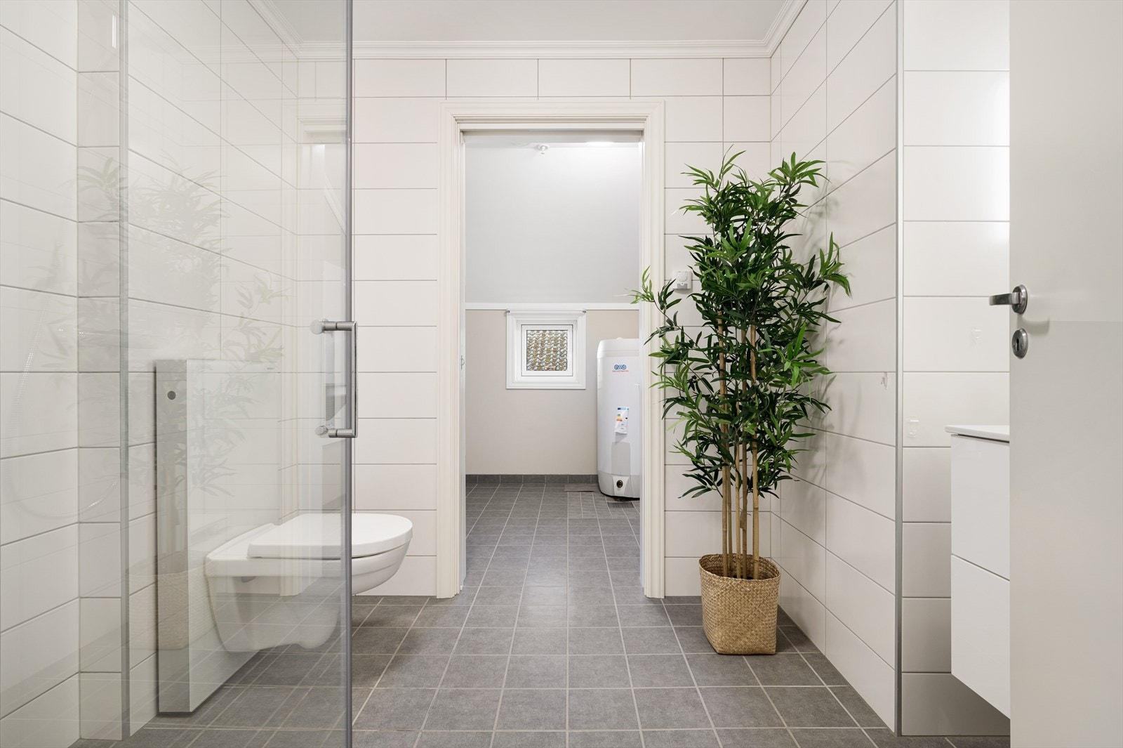 Bad og vaskerom med lyse, flislagte flater Galleribilde