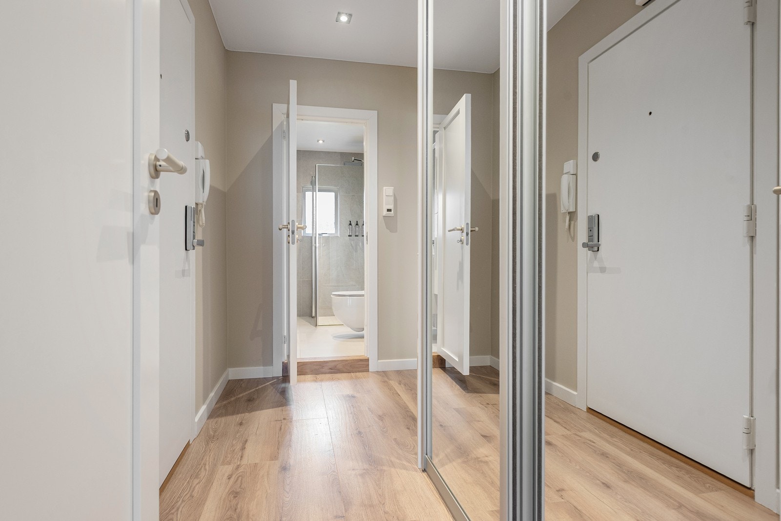 Entrè med porttelefon og praktisk skyvedørsgarderobe med speil Galleribilde