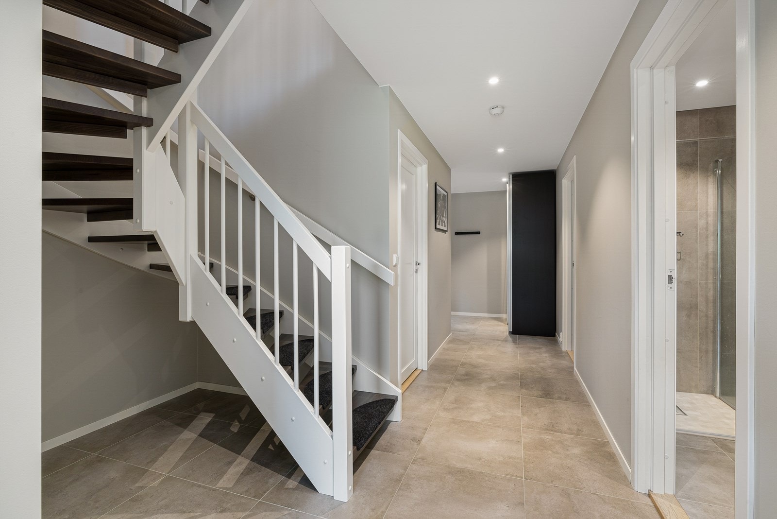 Vi tar turen ned i 1 etasje hvor du møtes av en lekker fliselagt gang med varme i gulv og downlights. Galleribilde