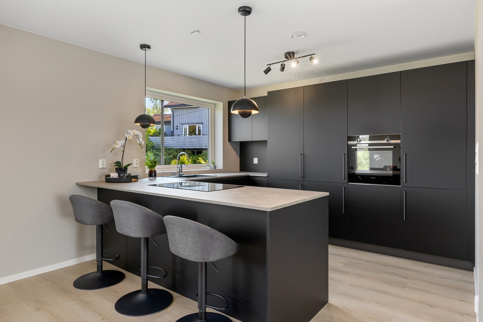 Lekkert kjøkkenet med innredning med glatte fronter fra
Italian Design i dempet sort farge. Benkeplaten er
av laminat med halvøy/bardisk. Galleribilde