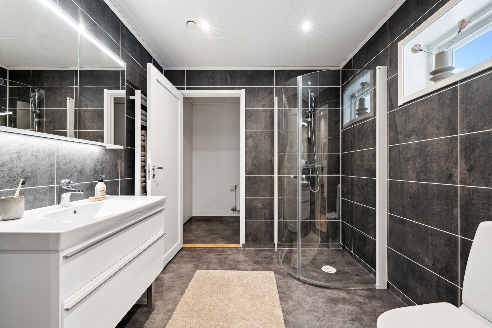 Baderommet har belegg på gulvet og våtromsplater på veggene. Det er elektrisk komfortvarme. Galleribilde