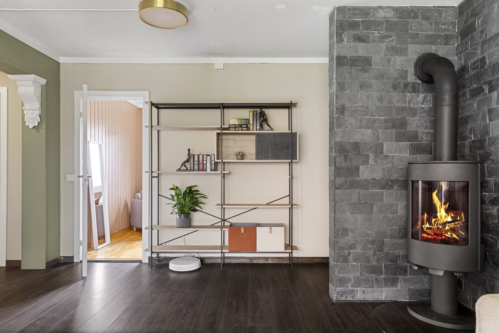 Foran et skiferkledd hjørne i stuen er det en rentbrennende peisovn. Galleribilde