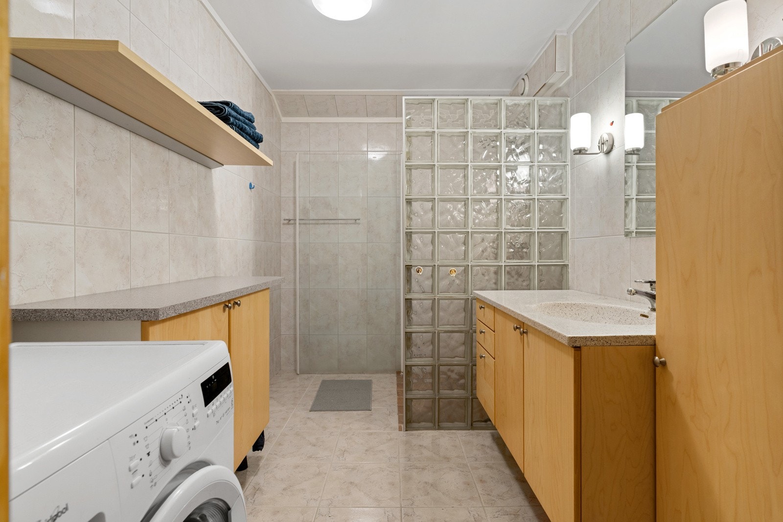 Badet måler 6 kvm og er utstyrt med en stor dusjnisje, stort baderomsmøblement med god oppbevaringsplass og opplegg for vaskemaskin. Galleribilde