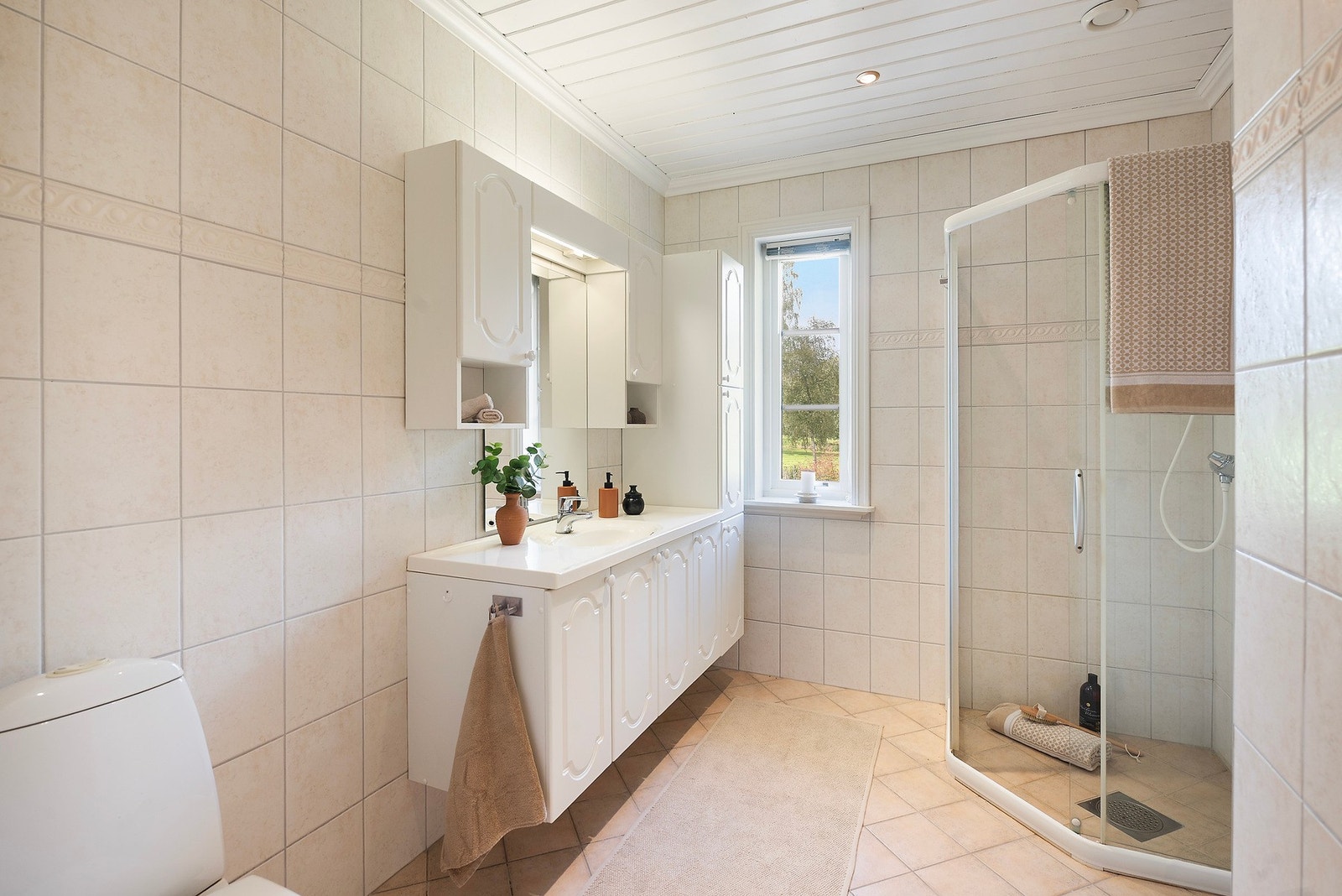 Badet er helfliset med varmekabler i gulvet og downlights i taket, innenfor badet er det også vaskerom Galleribilde