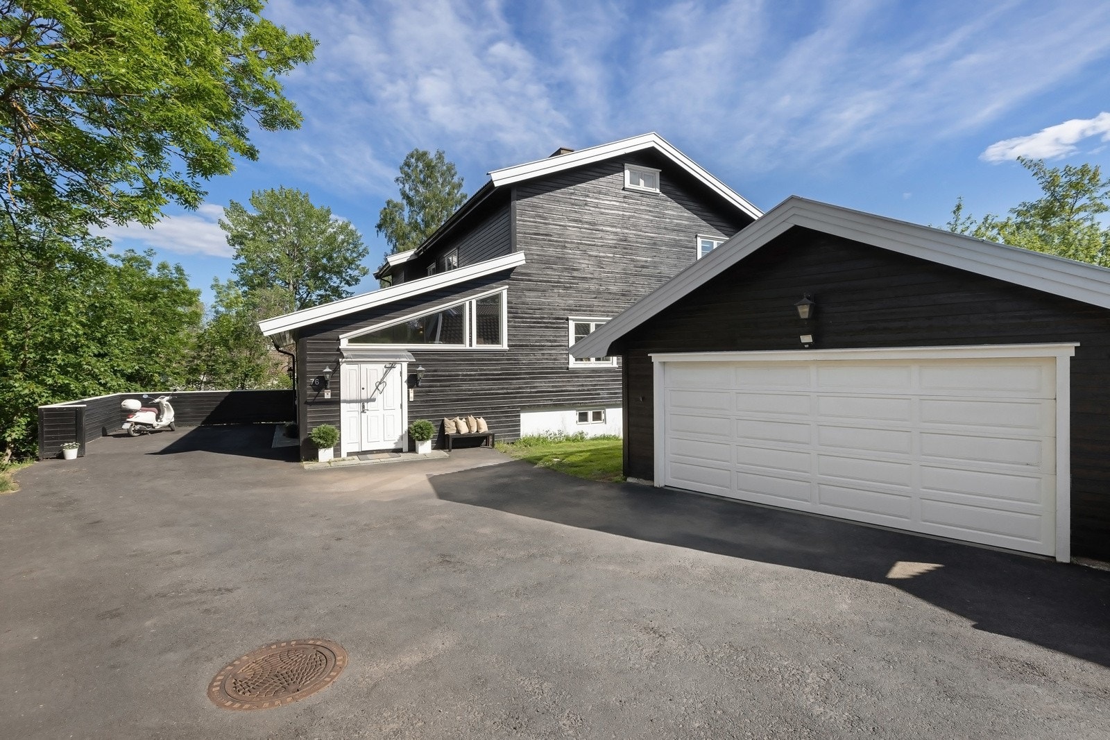 Stor frittstående garasje, med automatiske porter og en stor sportsbod i bakkant, som gir rikelig med oppbevaringsplass. Ellers biloppstilling på egen gårdsplass. Galleribilde