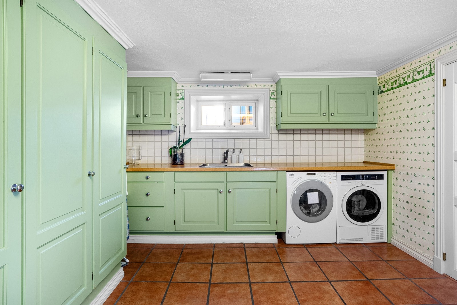 Vaskerom (U-etasje) - Delvis flislagt vaskerom med varmekabler, innredning med benkeplate og nedfelt utslagskum, samt opplegg for både vaskemaskin og tørketrommel. Galleribilde