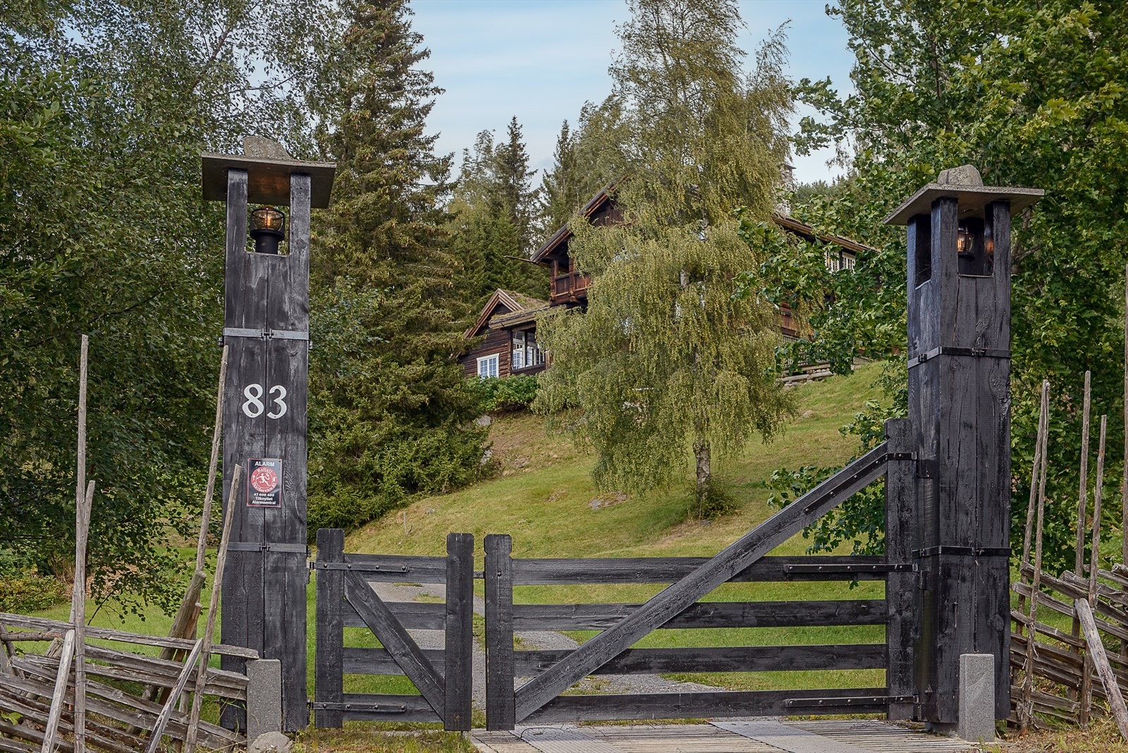 En tradisjonell norsk gårdsport ved åpner veien til en pittoresk eiendom. Galleribilde