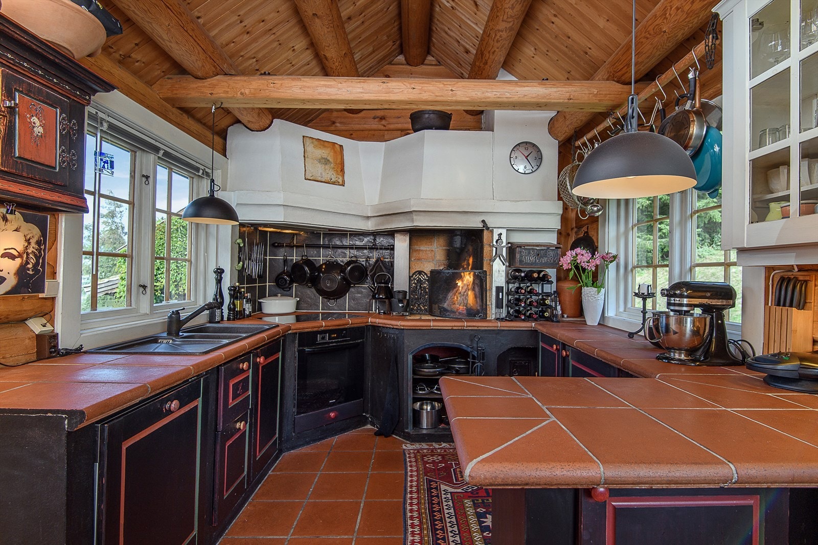 Kjøkkeninnredningen har en rustikk og varm atmosfære, med profilerte heltrefrontene er malt i sort og rød. Dette gir kjøkkenet et karakteristisk og tidløst uttrykk. Galleribilde