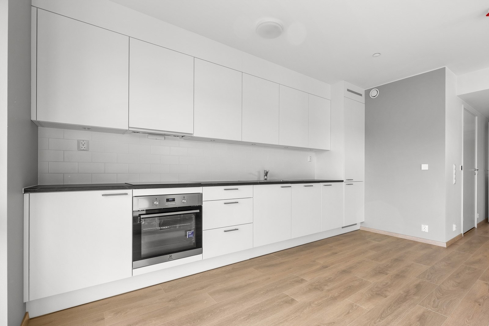 Kjøkkenet er utstyrt med integrerte hvitevarer: kjøl/frys, oppvaskmaskin, stekeovn, induksjonstopp og ventilator. Galleribilde