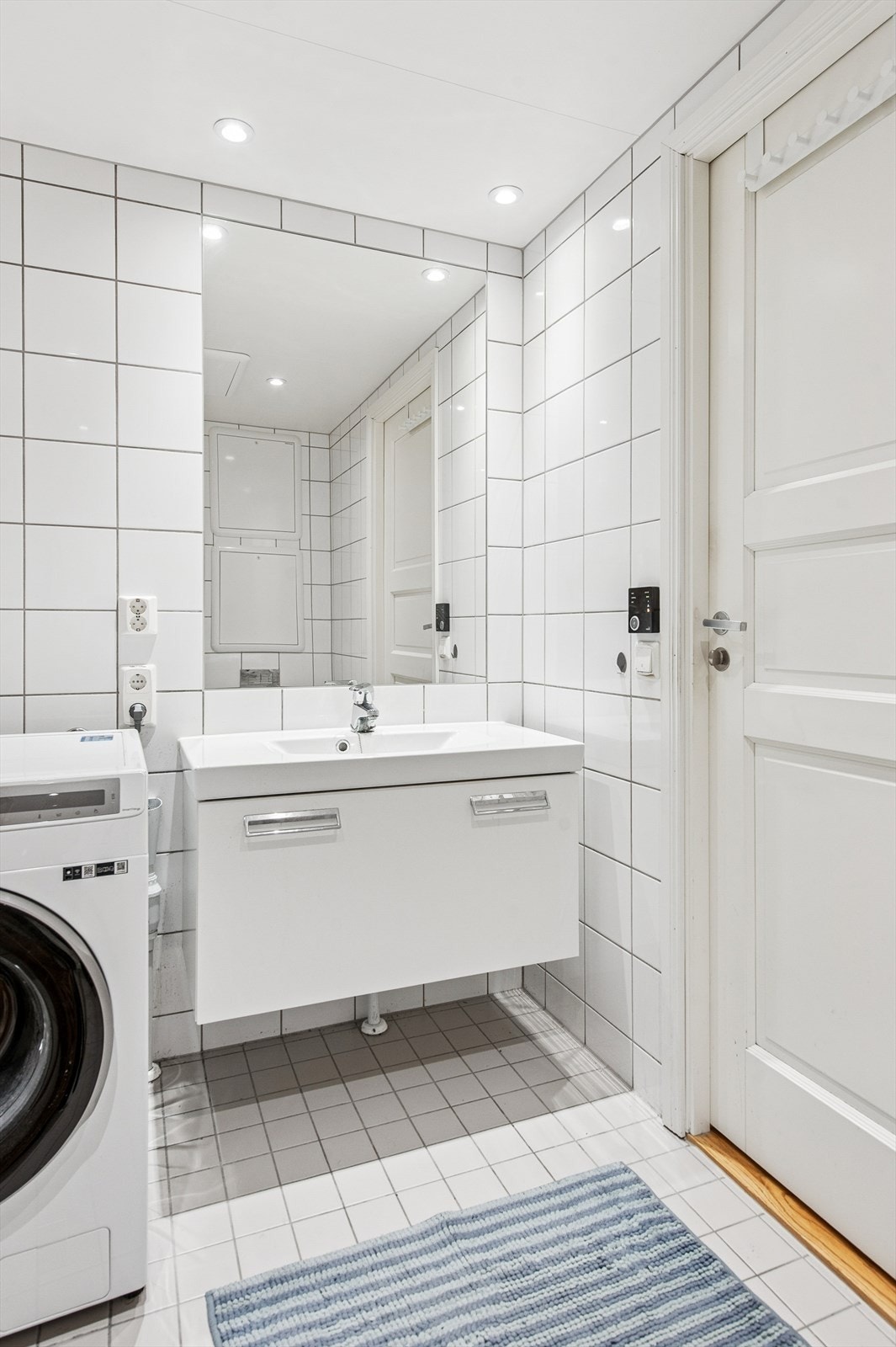 Badet er en prefabrikkert modul fra byggeår med flislagte overflater og downlights i taket. Galleribilde