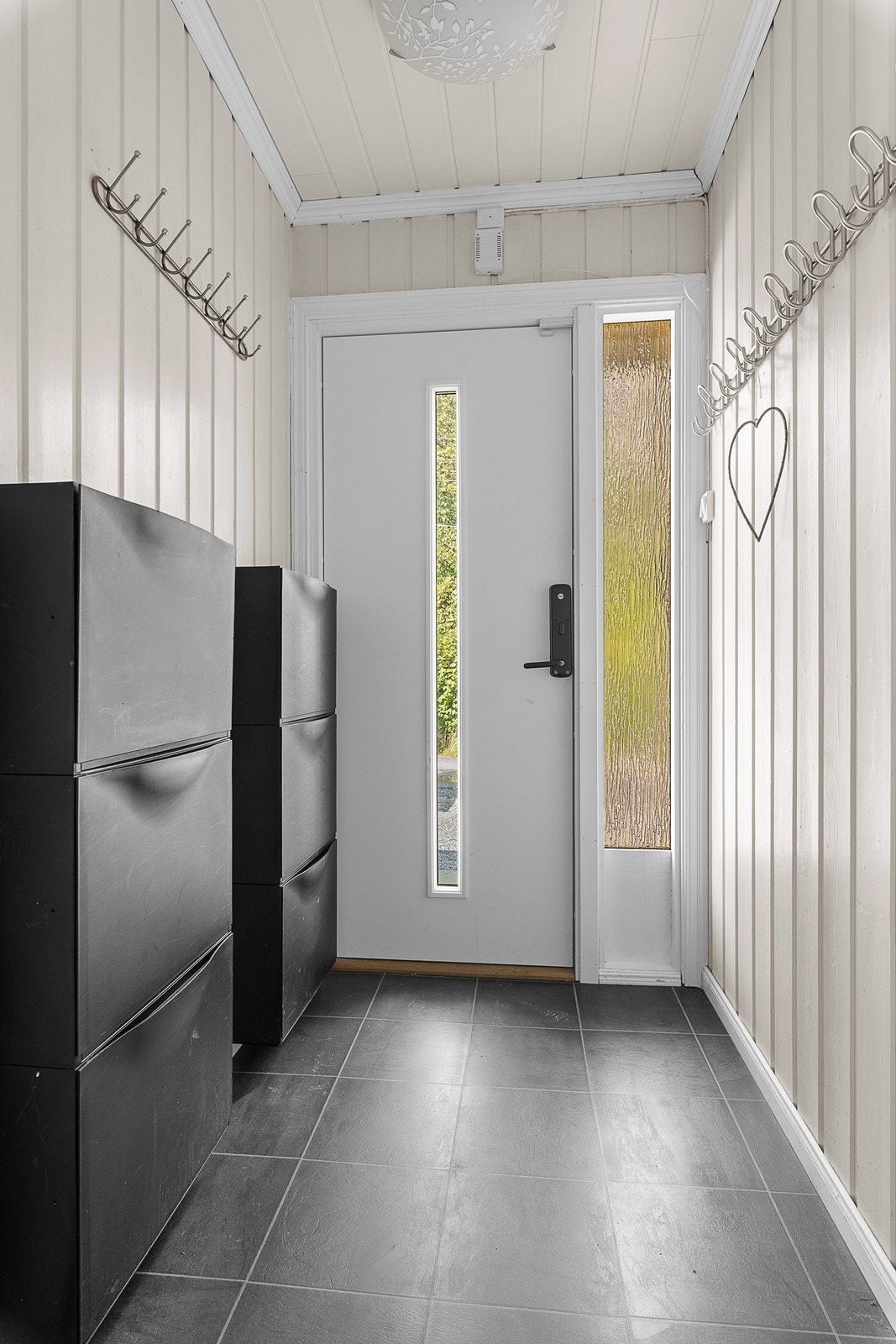 I boligen kommer du først inn i vindfang/gang. Herfra er det videre adkomst til bad, tre soverom, kjøkken, stue og nedgang til kjelleretasje. Galleribilde