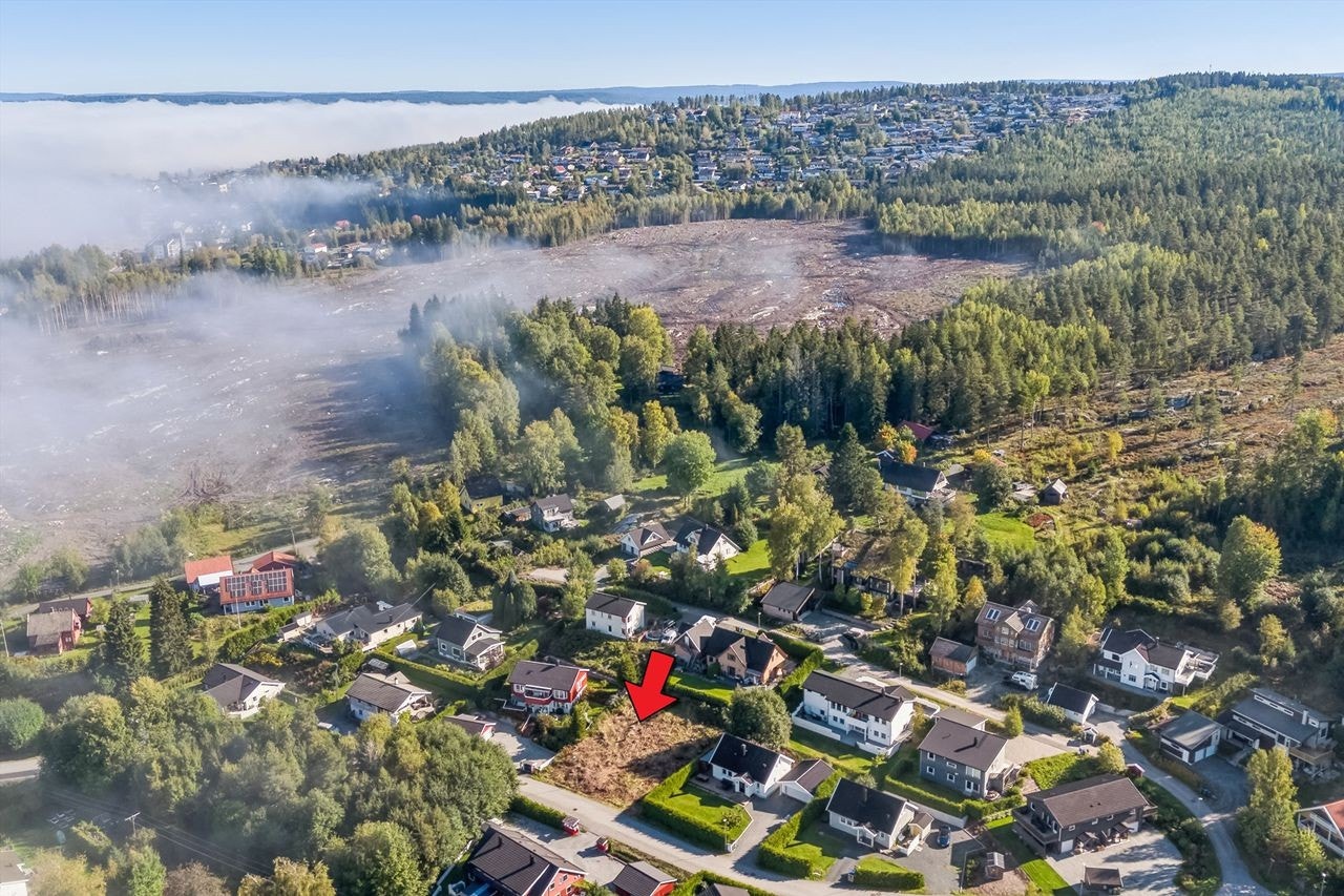 Krokskogen 16 - en solrik tomt i et veletablert og sentralt boligfelt på Rånåsfoss. I bakgrunnen ser man nedhogd område Olbergåsen hvor det vil være stor utvikling i nærmeste årene og bak der igjen Aulifeltet. Galleribilde