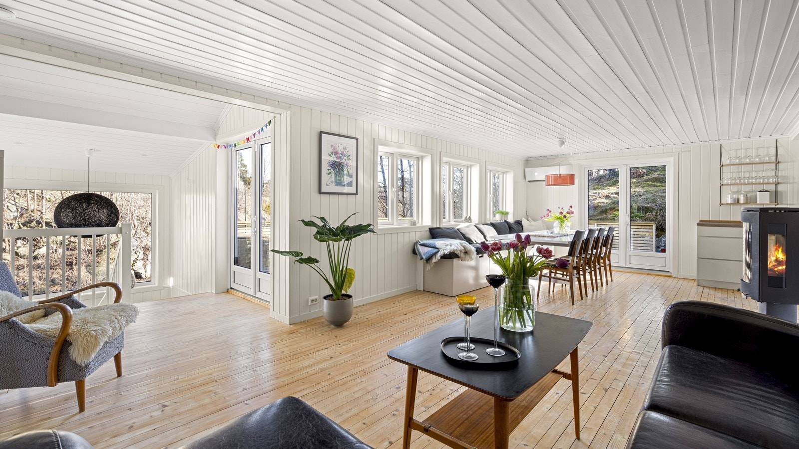 Lys og innholdsrikt oppholdsrom med masse naturlig lys fra alle vinduene Galleribilde