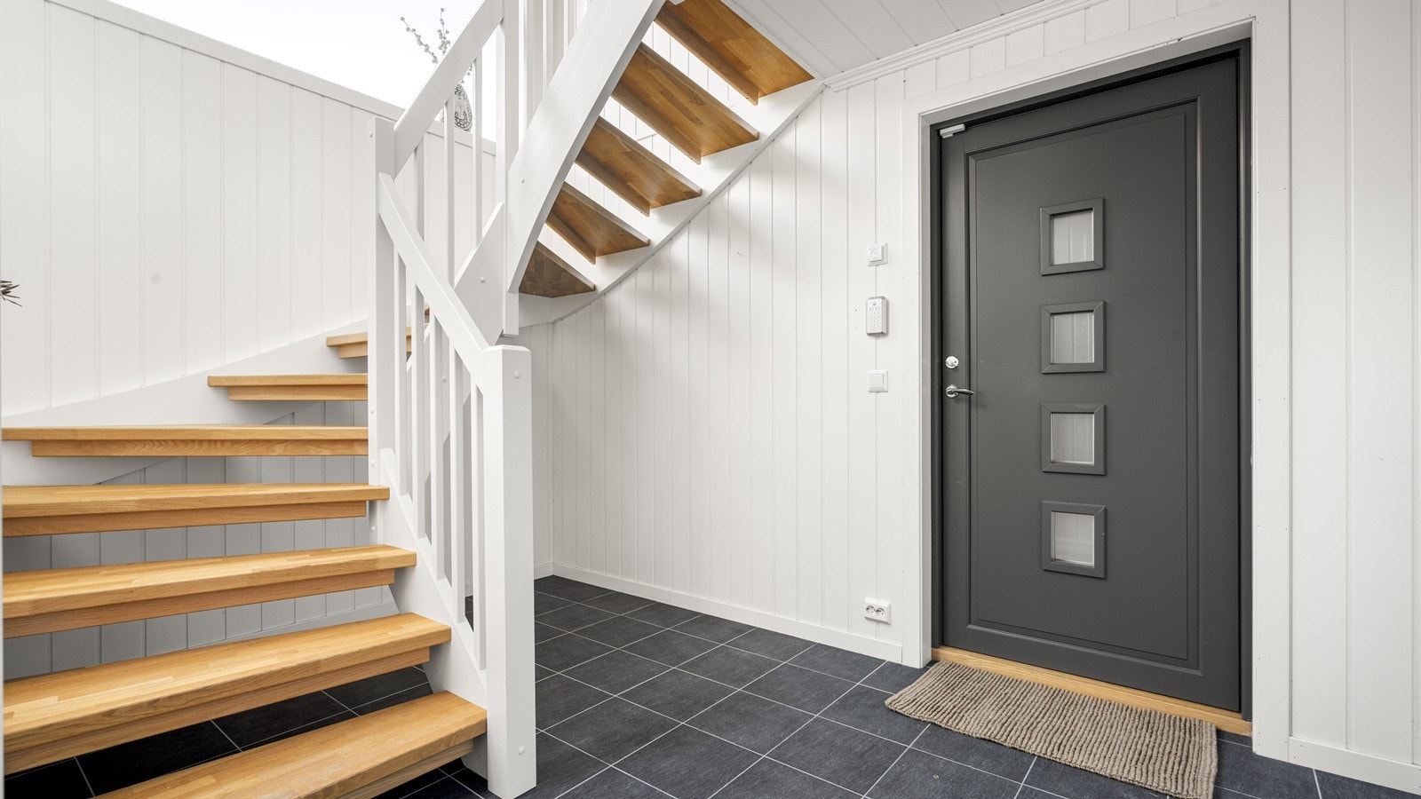 Lys og fin entré med flislagt gulv med varmekabler Galleribilde