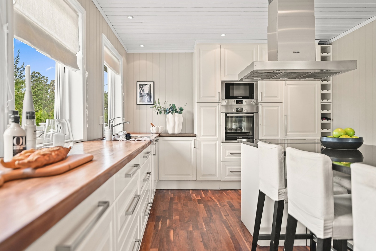 Innredningen er klassisk og tidløs, med profilerte, hvite fronter, underskap, skuffer og en hel vegg med takhøye skap. Galleribilde