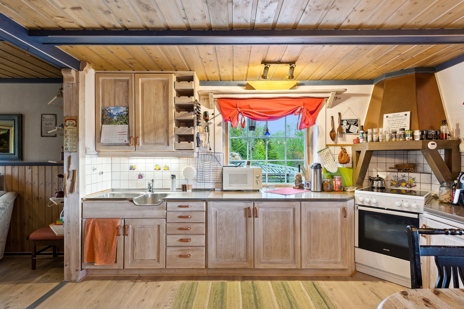 Funksjonelt kjøkken med solid heltre benkeplate og flislagt overflate over benk. Galleribilde