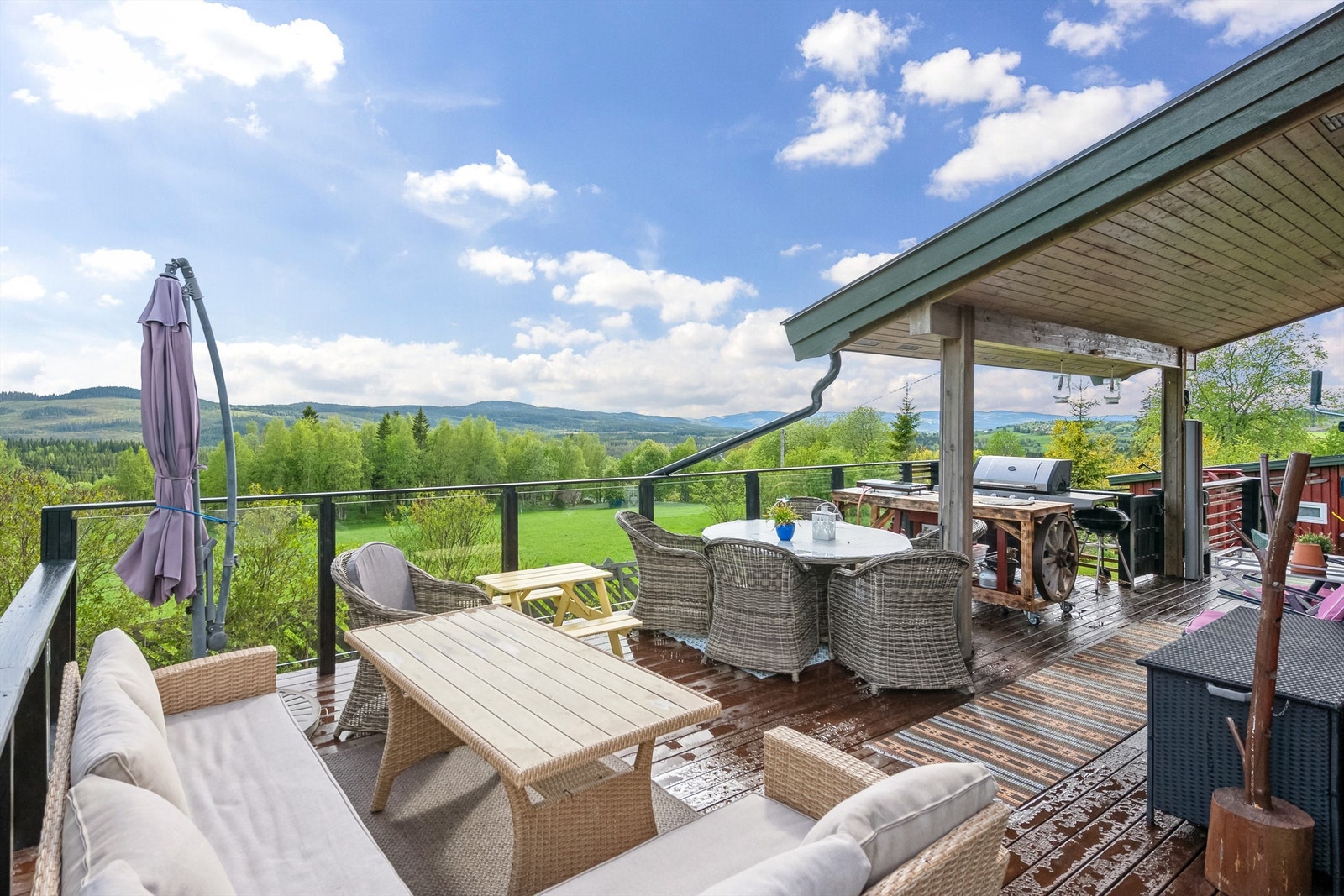 Stor delvis overbygd terrasse på 50 m² med tredekke og rekkverk i tre og glassfelt - ideell for lange sommerkvelder. Nyt også den vakre utsikten over bygda. Galleribilde