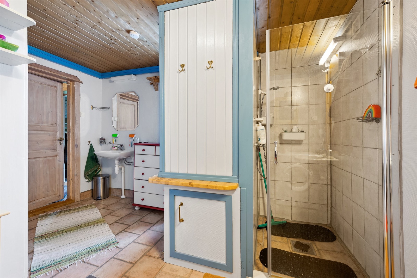 Dusjnisje med glassdør og flislagte vegger og mekanisk avtrekk for komfort og funksjonalitet. Galleribilde