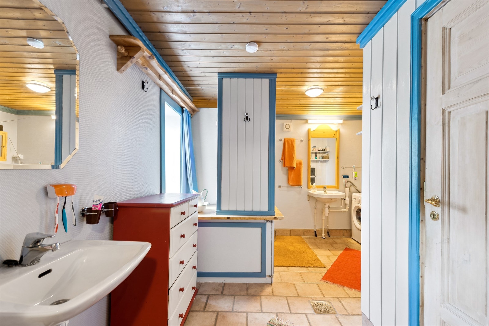 Badet har flislagt gulv med varme, praktisk innredning og panel på veggene. Galleribilde