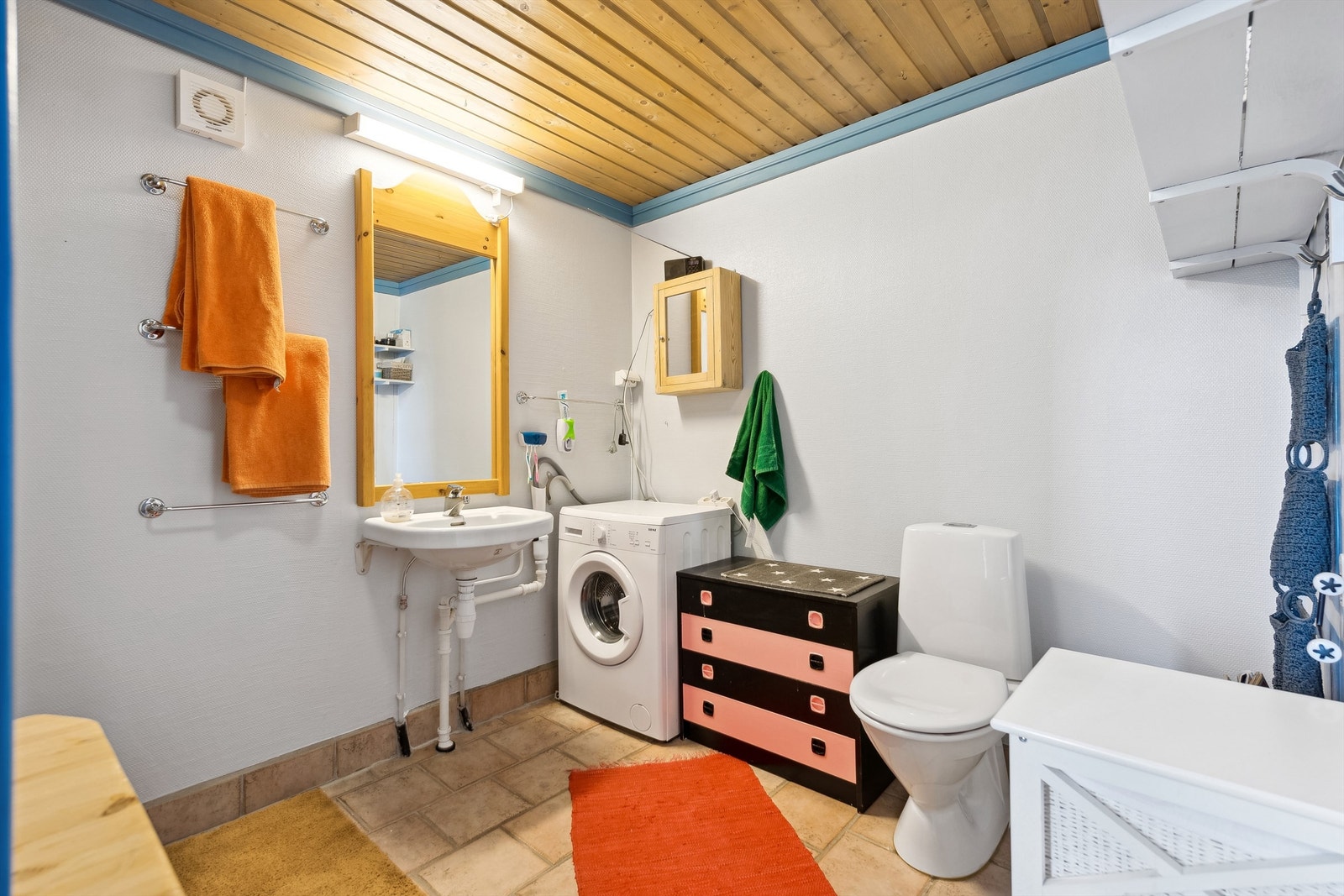 Eldre bad som er utstyrt med toalett, 2 vegghengte servanter, vaskemaskinopplegg og god plass til oppbevaring. Galleribilde