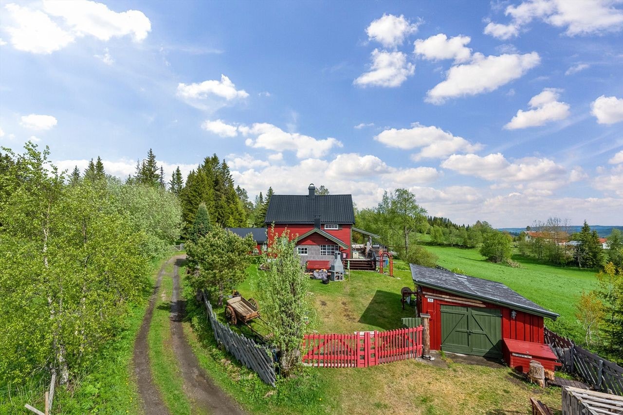 Usjenert beliggenhet på en frodig tomt med idyllisk innkjørsel med port. Åpent og luftig rundt eiendommen. Galleribilde