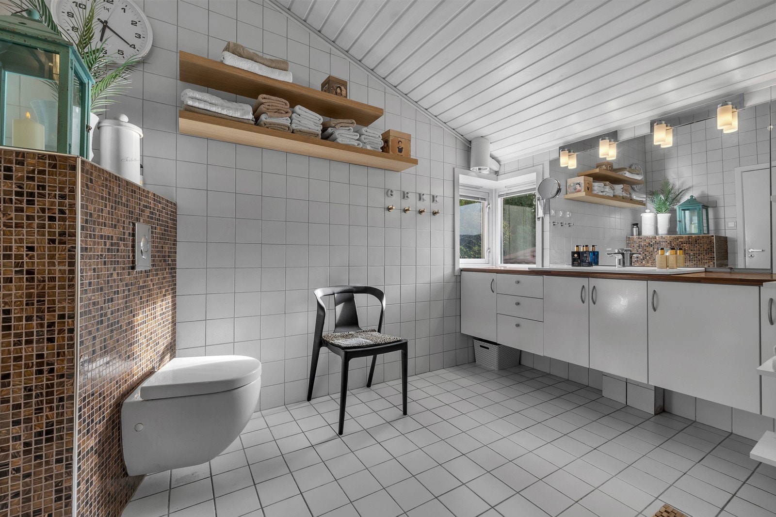 Badet er flislagt på både gulv og vegger, har stor innredning med god lagringsplass, vegghengt wc m.m. Galleribilde