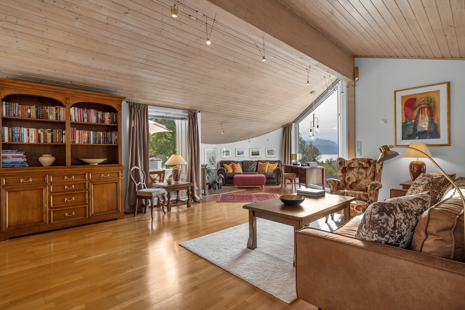 Stua er malt i lys farge som fint brytes av panel i taket Galleribilde