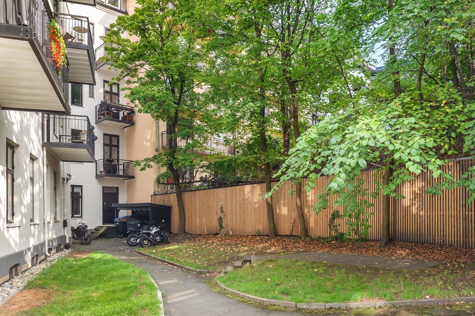 Pent opparbeidet bakgård med diverse beplantning og sykkelstativ. Galleribilde