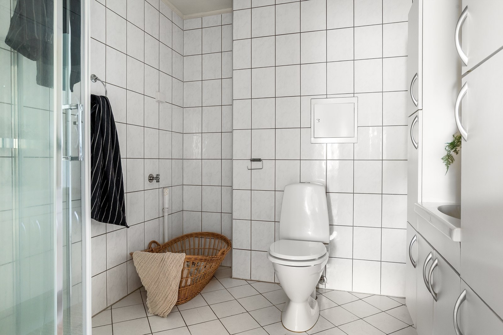 Helfilset baderom med elektriske varmekabler i gulvet. Innredning består av dusjkabinett med blandebatteri, frittstående toalett, innredning med heldekkende servant med ett-greps blandebatteri og speil. Galleribilde