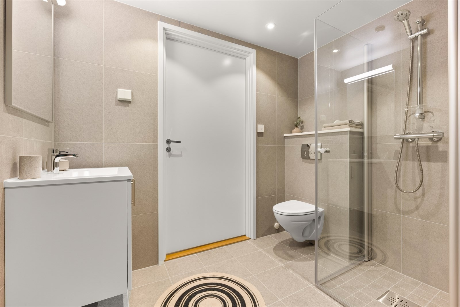 Lyst og delikat bad med flislagte overflater og gulvvarme for økt komfort. Galleribilde