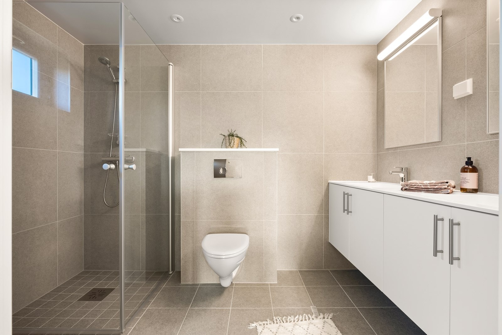 Eget bad med adkomst fra hovedsoverommet. Dobbel servant i innredningen. Vegghengt wc og dusjhjørne. Galleribilde