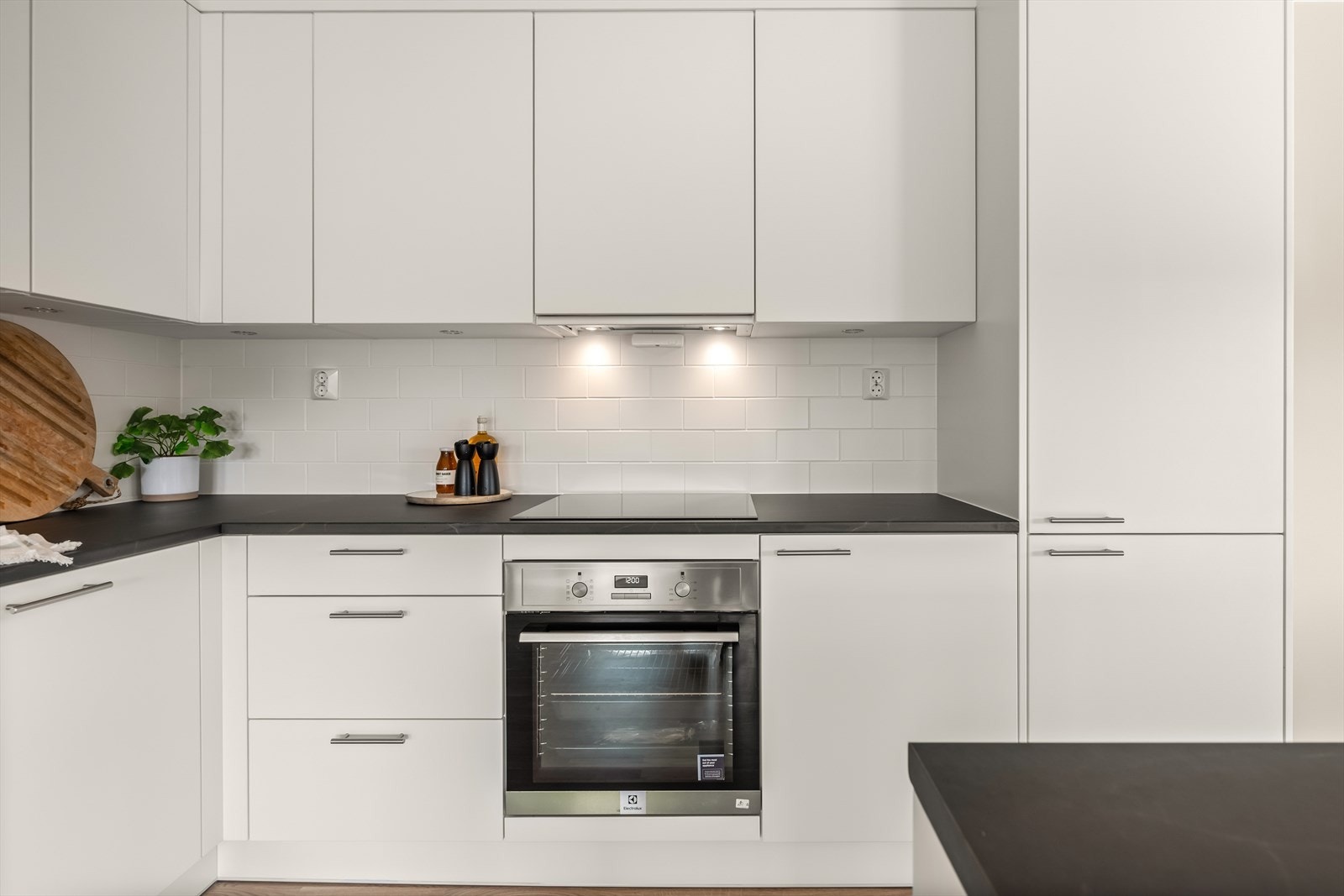 Kjøkkenet er utstyrt med integrerte hvitevarer: kjøl/frys, oppvaskmaskin, stekeovn, induksjonstopp og ventilator. Galleribilde