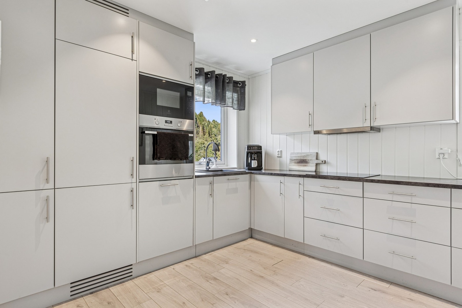 Kjøkkenet er utstyrt med integrerte hvitevarer som oppvaskmaskin, platetopp, stekeovn, mikroovn og kjøleskap. Galleribilde