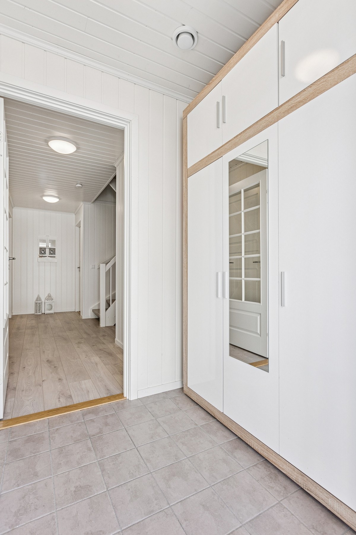 Innbydende entré med flislagt gulv og gulvvarme - en praktisk og komfortabel løsning som gjør det enkelt å holde rent, spesielt i den travle hverdagen. Galleribilde